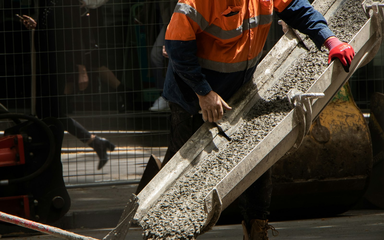 Concrete finishing work in progress on a paved surface