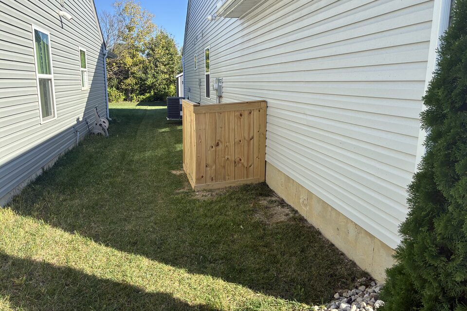 Wood privacy enclosure fence around outdoor equipment